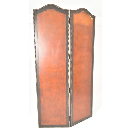 553 - A vintage 20th century mahogany & studded leather two fold discretion screen. The screen featuring c... 