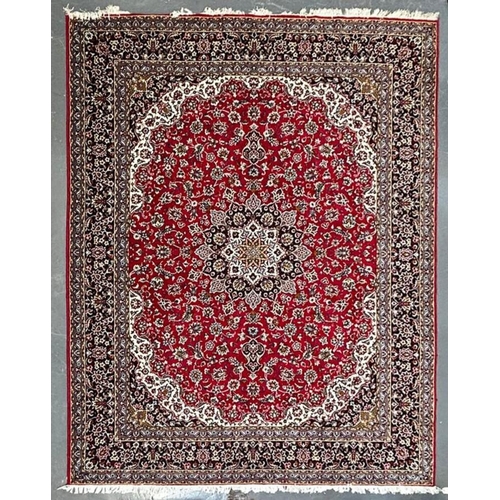 561 - A large 20th century Iranian Islamic floor carpet rug. The rug having a red panel with floral shaped... 