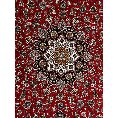 561 - A large 20th century Iranian Islamic floor carpet rug. The rug having a red panel with floral shaped... 