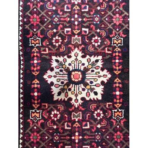 563 - A 20th century North-West Persian Islamic Malayer floor carpet runner rug. The rug having a central ... 