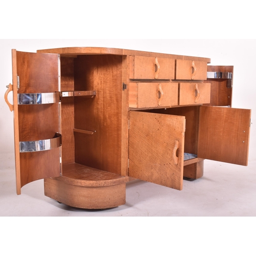 575 - Heals Of London - A 20th century Art Deco oak sideboard credenza. The sideboard of curved form havin... 