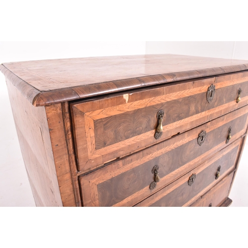 585 - An 18th century Queen Anne oak and burr walnut chest of drawers. The chest of drawers having crossba... 