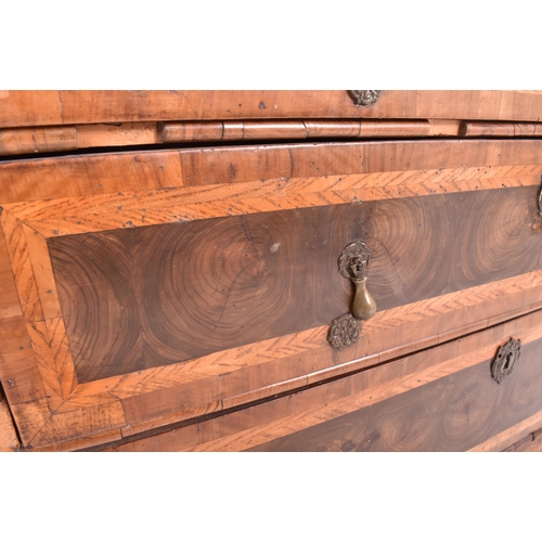 585 - An 18th century Queen Anne oak and burr walnut chest of drawers. The chest of drawers having crossba... 