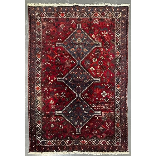 587 - A 19th century Khamseh Confederation floor carpet rug. The rug having three geometric dark ground me... 