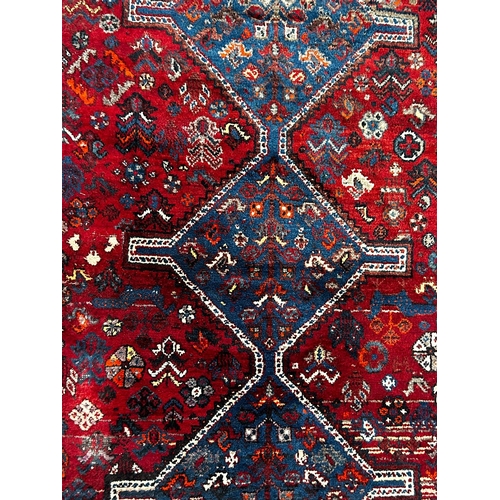 587 - A 19th century Khamseh Confederation floor carpet rug. The rug having three geometric dark ground me... 