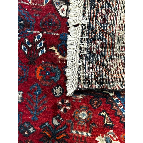 587 - A 19th century Khamseh Confederation floor carpet rug. The rug having three geometric dark ground me... 