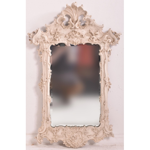 590 - A continental inspired Baroque style white painted wood ornate wall hanging mirror. The mirror havin... 