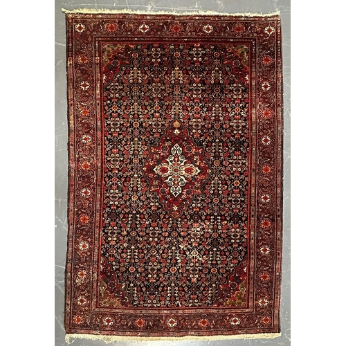 597 - A 20th century Persian Islamic Kashan floor carpet rug. The rug having a central floral medallion wi... 