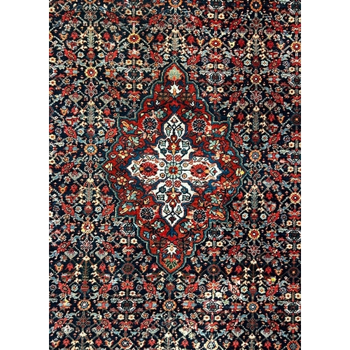 597 - A 20th century Persian Islamic Kashan floor carpet rug. The rug having a central floral medallion wi... 