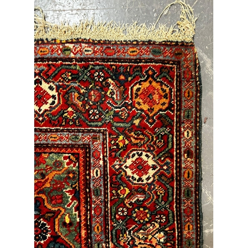 597 - A 20th century Persian Islamic Kashan floor carpet rug. The rug having a central floral medallion wi... 