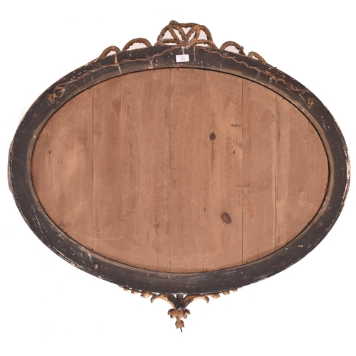 602 - A Victorian 19th century gilt gesso and wooden oval wall hanging mirror. The mirror having a ribbon ... 