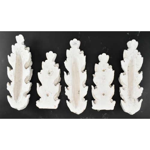 604 - A collection of five 20th century cast plaster architectural embellishments in the shape of acanthus... 