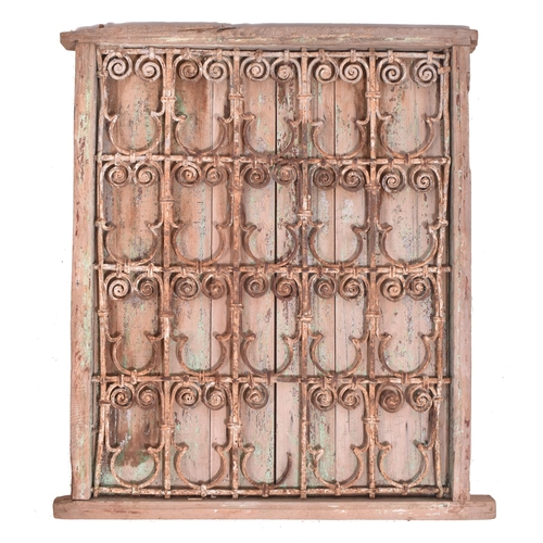 606 - A 20th century Moroccan pine framed window. The window of rectangular form having a pine surround an... 