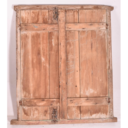 606 - A 20th century Moroccan pine framed window. The window of rectangular form having a pine surround an... 