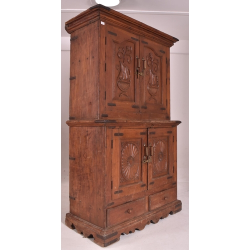 612 - An Indian early 20th century carved hardwood & iron bound cupboard wardrobe. The cabinet having a pe... 