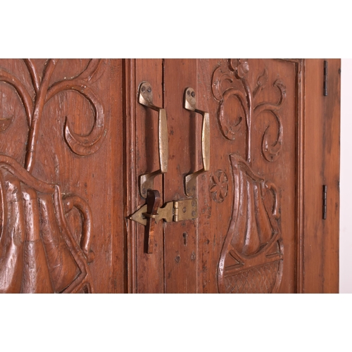 612 - An Indian early 20th century carved hardwood & iron bound cupboard wardrobe. The cabinet having a pe... 