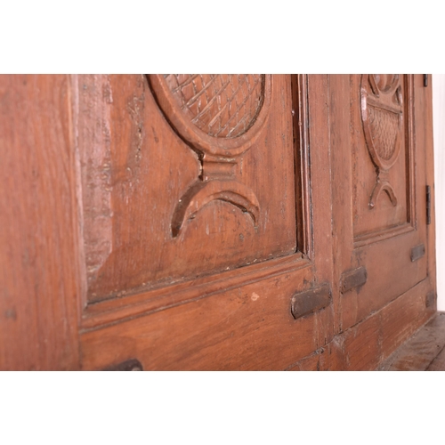 612 - An Indian early 20th century carved hardwood & iron bound cupboard wardrobe. The cabinet having a pe... 