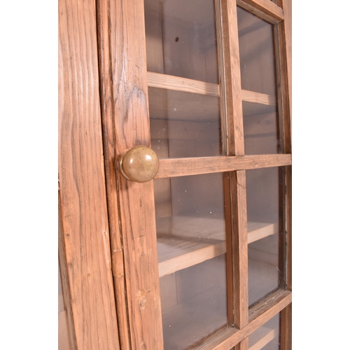 615 - A 20th century pine wood country house wall hanging glazed front bookcase cabinet. The bookcase havi... 