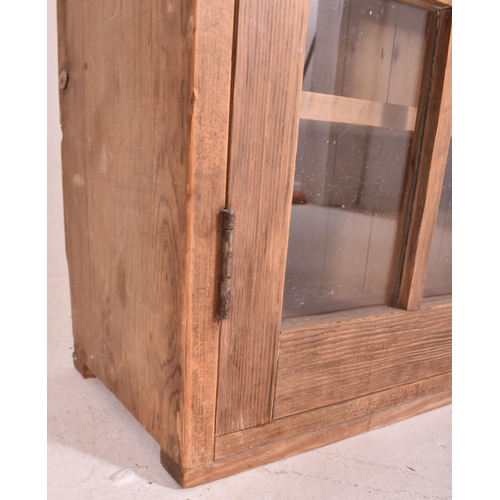 615 - A 20th century pine wood country house wall hanging glazed front bookcase cabinet. The bookcase havi... 