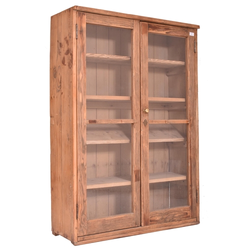 617 - A 20th century pine wood country house wall hanging glazed front bookcase cabinet. The bookcase havi... 