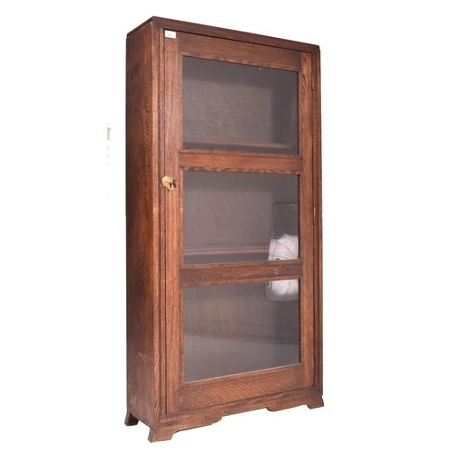 619 - A 20th century oak & glazed front bookcase cabinet converted from a rifle / gun cabinet. The bookcas... 