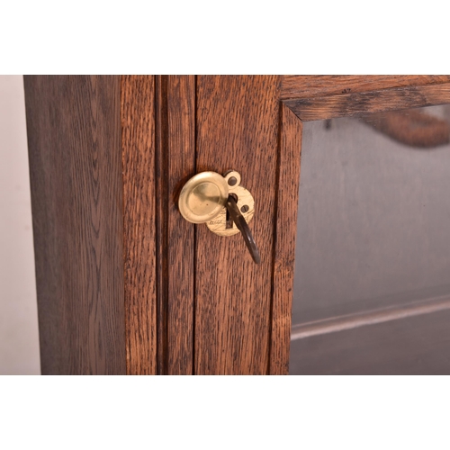 619 - A 20th century oak & glazed front bookcase cabinet converted from a rifle / gun cabinet. The bookcas... 