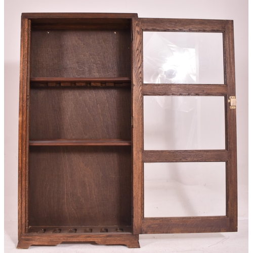 619 - A 20th century oak & glazed front bookcase cabinet converted from a rifle / gun cabinet. The bookcas... 