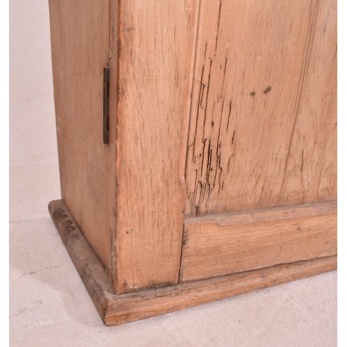 622 - An early 20th century pine wall mounted school cupboard. The cupboard having a pediment top over dou... 