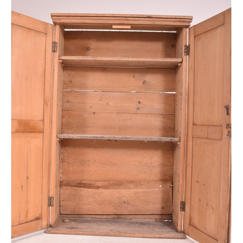 622 - An early 20th century pine wall mounted school cupboard. The cupboard having a pediment top over dou... 