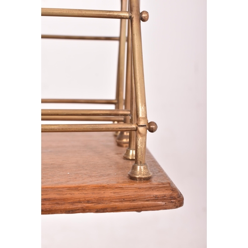 627 - A Victorian 19th century brass & oak magazine stand. The stand having five brass tubular magazine se... 