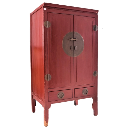 638 - An early 20th century Chinese red lacquer marriage cabinet. The twin panelled doors with shelves set... 