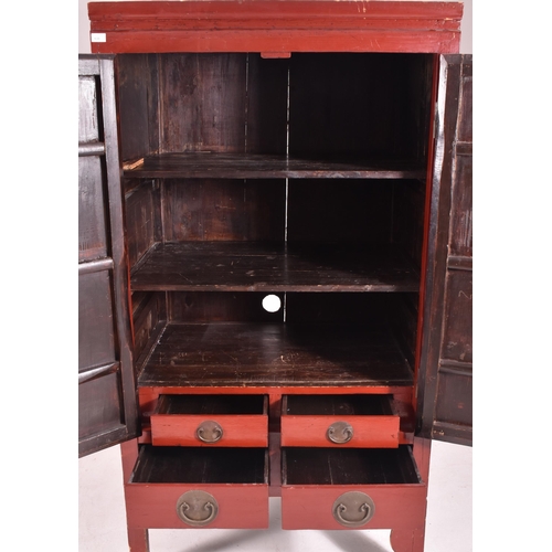 638 - An early 20th century Chinese red lacquer marriage cabinet. The twin panelled doors with shelves set... 