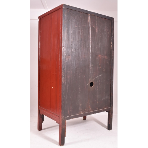 638 - An early 20th century Chinese red lacquer marriage cabinet. The twin panelled doors with shelves set... 