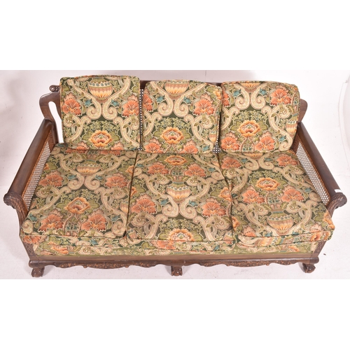 640 - An early 20th century three piece mahogany and double caned bergere suite. The suite comprising a th... 