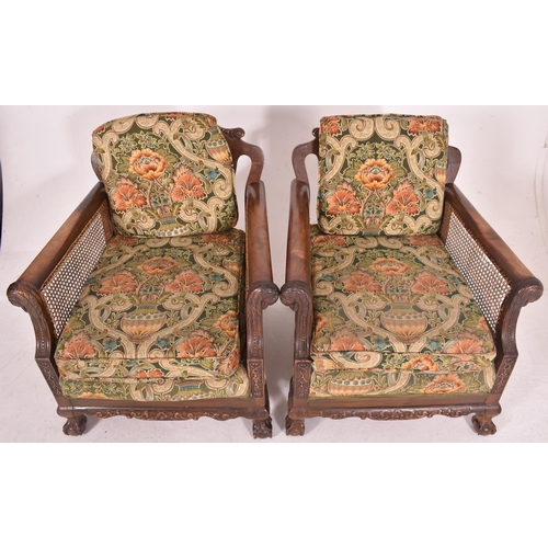 640 - An early 20th century three piece mahogany and double caned bergere suite. The suite comprising a th... 