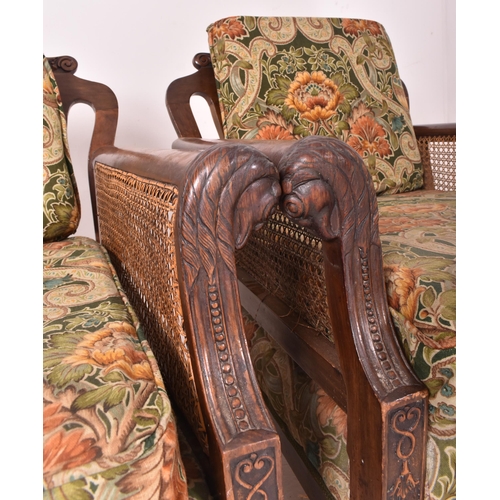 640 - An early 20th century three piece mahogany and double caned bergere suite. The suite comprising a th... 