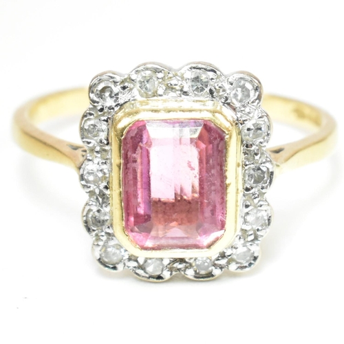 23 - A hallmarked 18ct gold pink tourmaline and diamond halo ring. The ring set with a central emerald cu... 