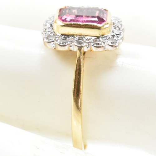 23 - A hallmarked 18ct gold pink tourmaline and diamond halo ring. The ring set with a central emerald cu... 