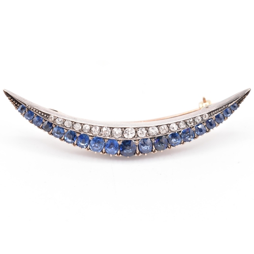 26 - A sapphire and diamond crescent brooch pin. The late 19th century/early 20th century crescent brooch... 