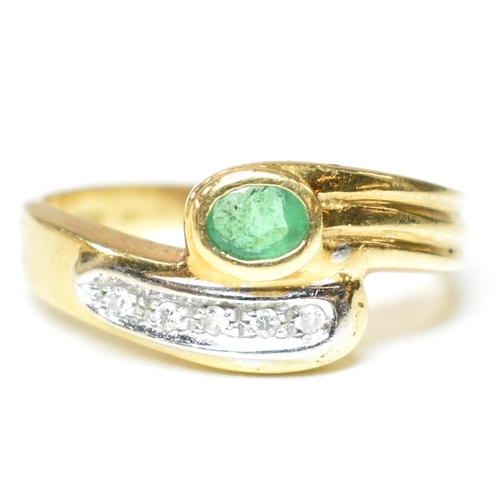 43 - A hallmarked Italian 18ct gold, diamond and emerald cross over ring. The ring having a central bezel... 