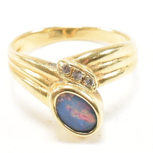 49 - An 18ct gold, diamond and opal ring. The ring having a central bezel set opal flanked by three round... 