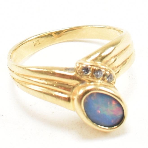 49 - An 18ct gold, diamond and opal ring. The ring having a central bezel set opal flanked by three round... 