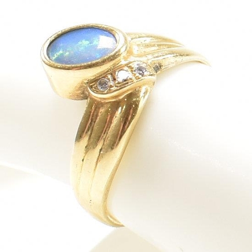 49 - An 18ct gold, diamond and opal ring. The ring having a central bezel set opal flanked by three round... 