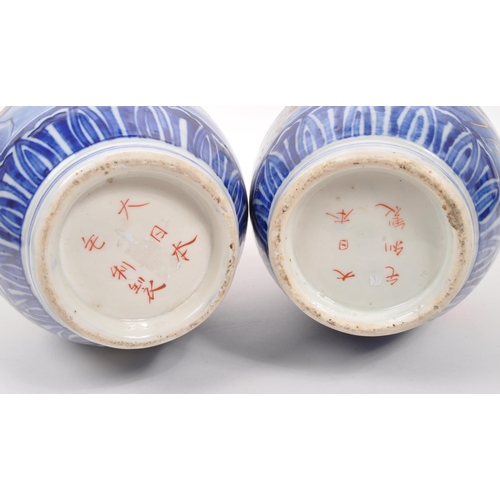 130 - A pair of early 20th century Japanese Meiji era china vases. Each vase raised on a rounded base havi... 