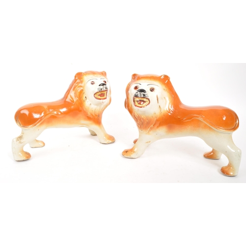 161 - A pair of 19th century ceramic pottery fireside Staffordshire wild cat lions. In standing positions ... 