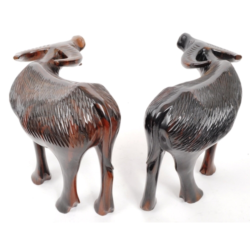 200 - A pair of 20th Century carved hardwood figures in the form of water buffalos. Both standing with hea... 