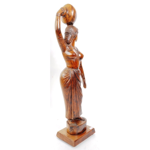 203 - A large 20th Century carved hardwood figurine / sculpture of Indian female carrying water bowl to he... 