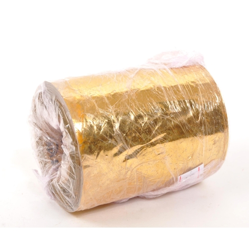 219 - A 22/24ct gold leaf roll. The roll having central cardboard tube with plastic backed gold leaf. Weig... 