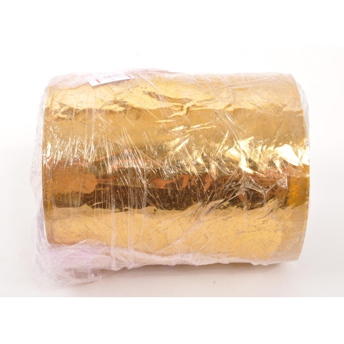 219 - A 22/24ct gold leaf roll. The roll having central cardboard tube with plastic backed gold leaf. Weig... 