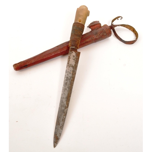 253 - An early 20th Century bone handled knife / letter opener held within red leather sheath. Measuring a... 